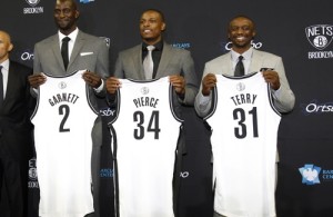 Newly acquired Net's Pierce, Garnett and Terry hold up their new jerseys as they pose for a photo with the NBA team's principal owner Prokhorov, general manager King and head coach Kidd in Brooklyn